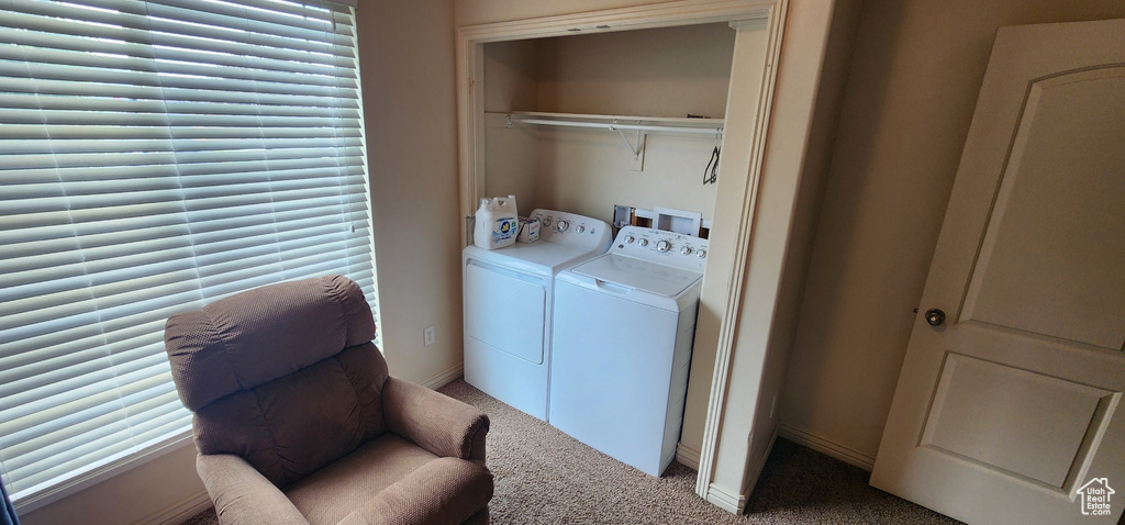 Washroom with washing machine and clothes dryer and light carpet