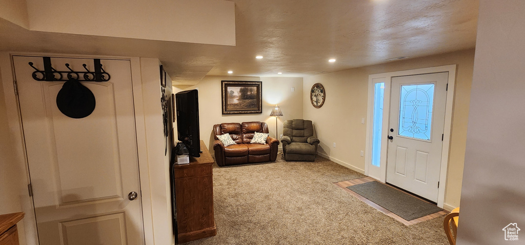 Carpeted entryway with recessed lighting and baseboards