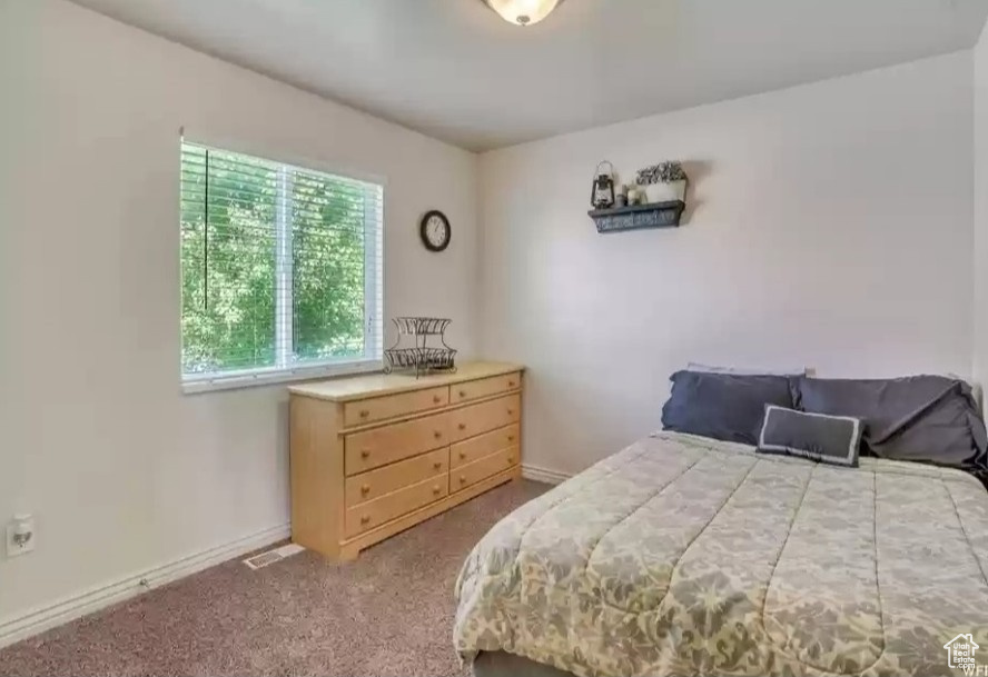 Bedroom featuring carpet floors and baseboards