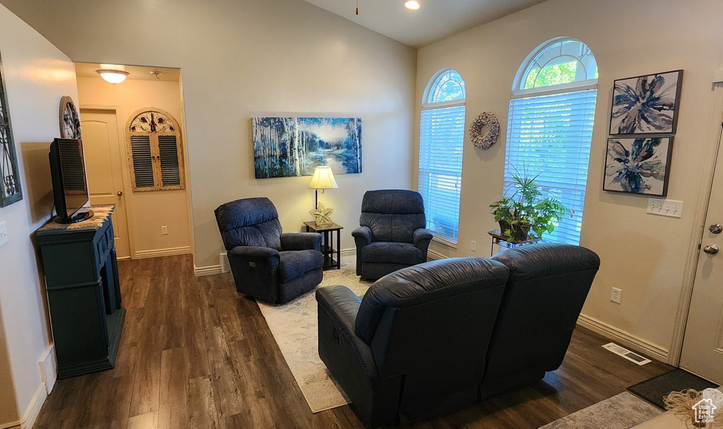 Living room featuring dark wood-style flooring, baseboards, and recessed lighting
