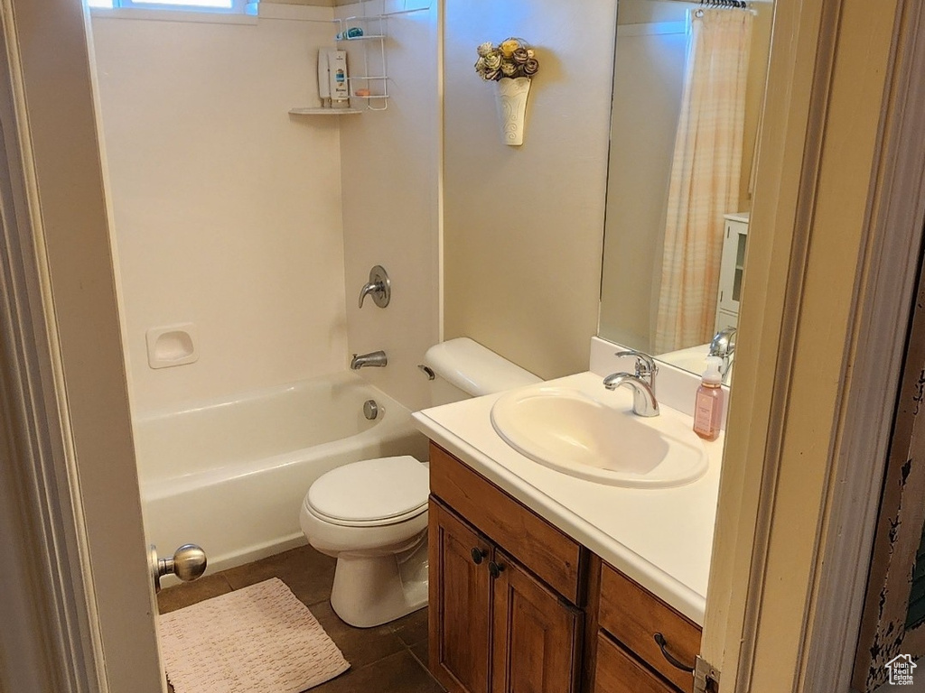 Bathroom featuring vanity, tile patterned floors, shower / tub combo, and toilet