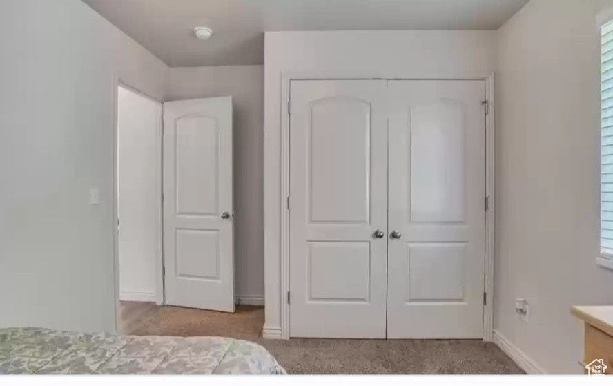 Unfurnished bedroom with a closet, baseboards, and carpet flooring