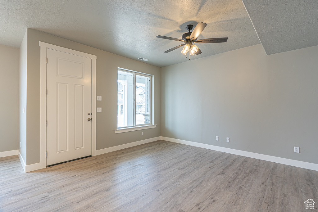 Foyer featuring a textured ceiling, light wood-style floors, and a ceiling fan