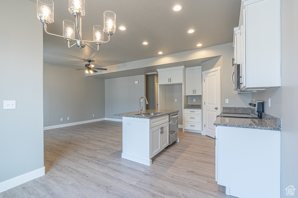 Kitchen with stainless steel appliances, a chandelier, recessed lighting, a ceiling fan, and dark stone countertops