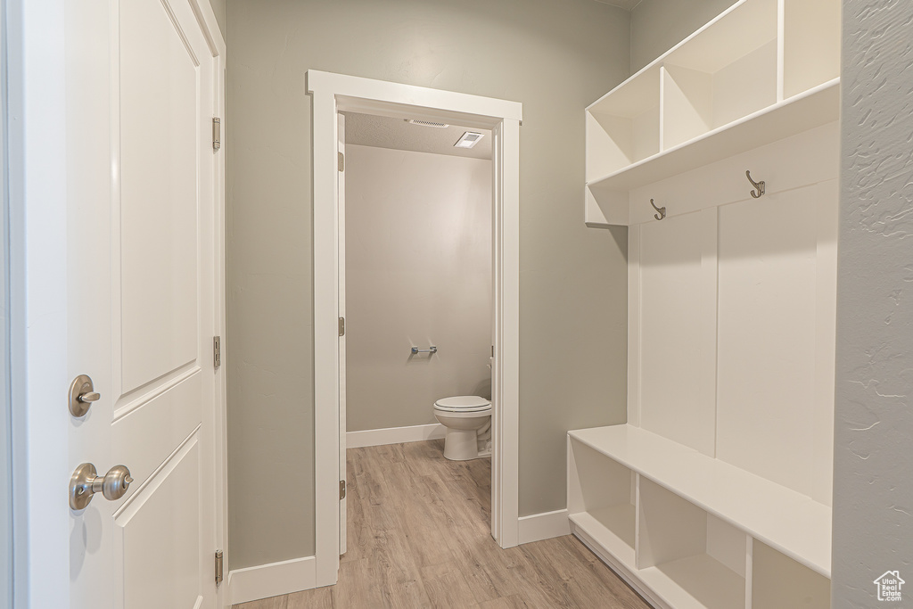 Mudroom featuring light wood finished floors and baseboards