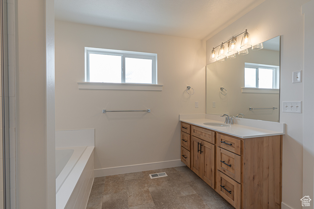 Full bath with vanity and a bath