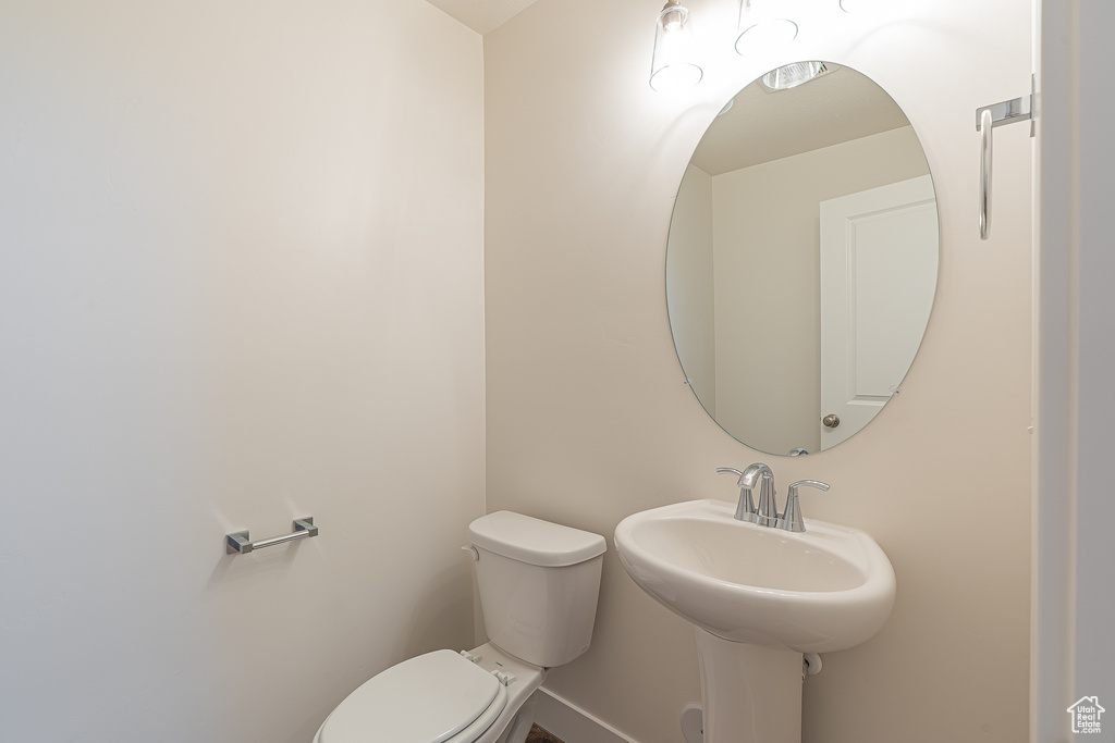 Half bath featuring toilet and baseboards
