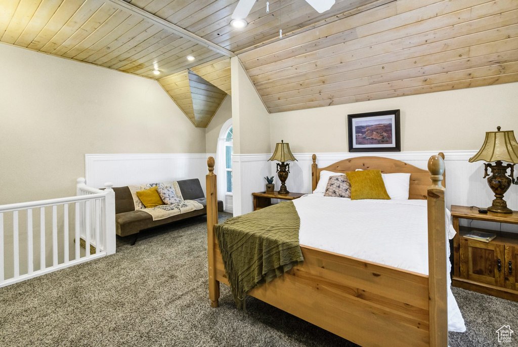 Bedroom featuring wooden ceiling, carpet, lofted ceiling, and wainscoting