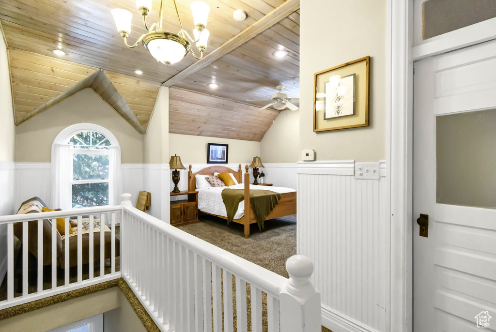 Bedroom featuring wooden ceiling, wainscoting, vaulted ceiling, and a chandelier