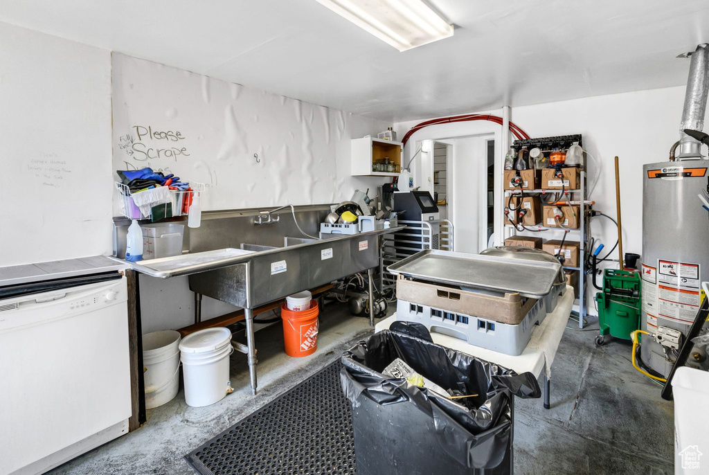 Kitchen with dishwasher, unfinished concrete floors, and water heater