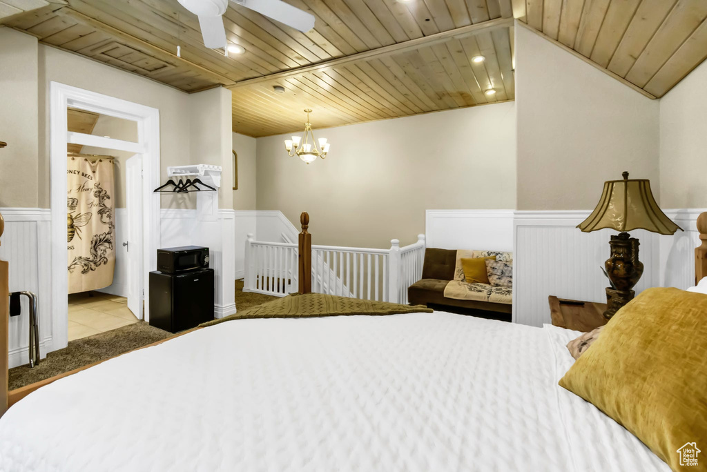 Tiled bedroom featuring wood ceiling, a wainscoted wall, a chandelier, and recessed lighting