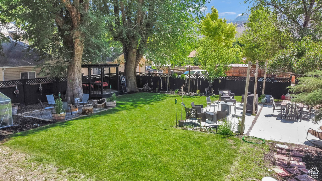 Fenced yard with a patio area, an outdoor fire pit, and a mountain view