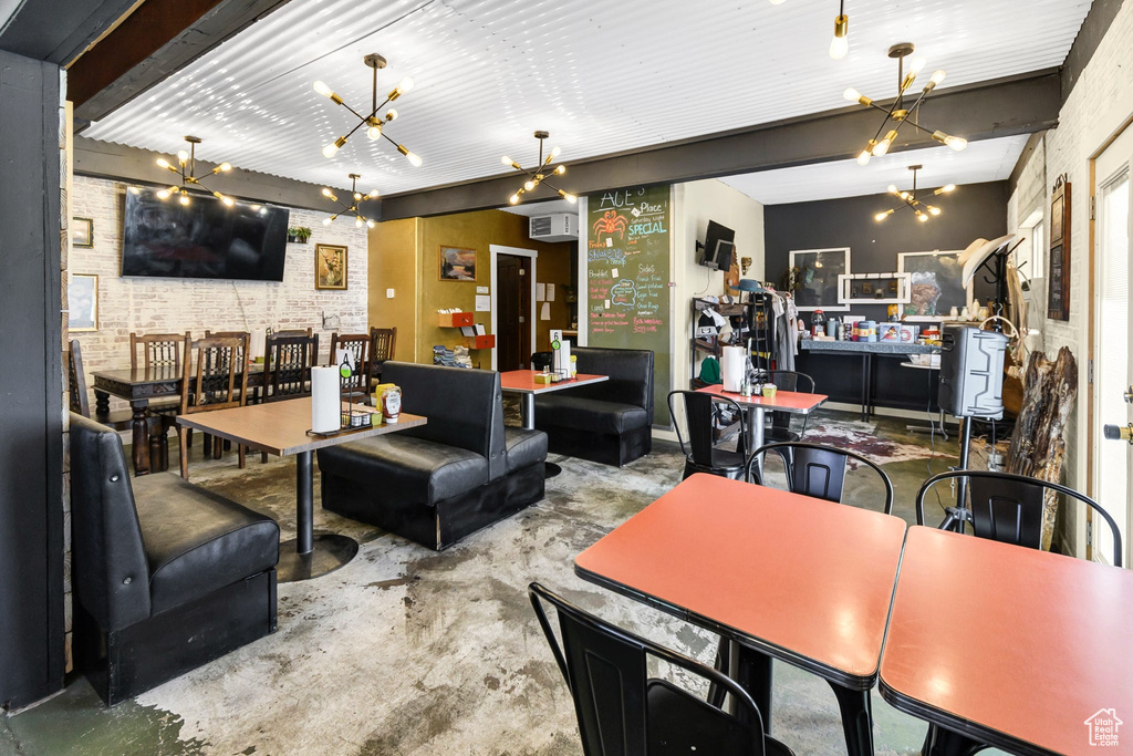 Living room with concrete floors, a wall mounted air conditioner, and a chandelier