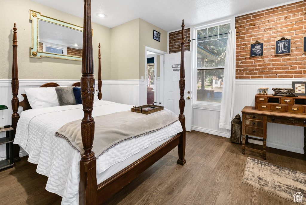 Bedroom with wood finished floors and wainscoting