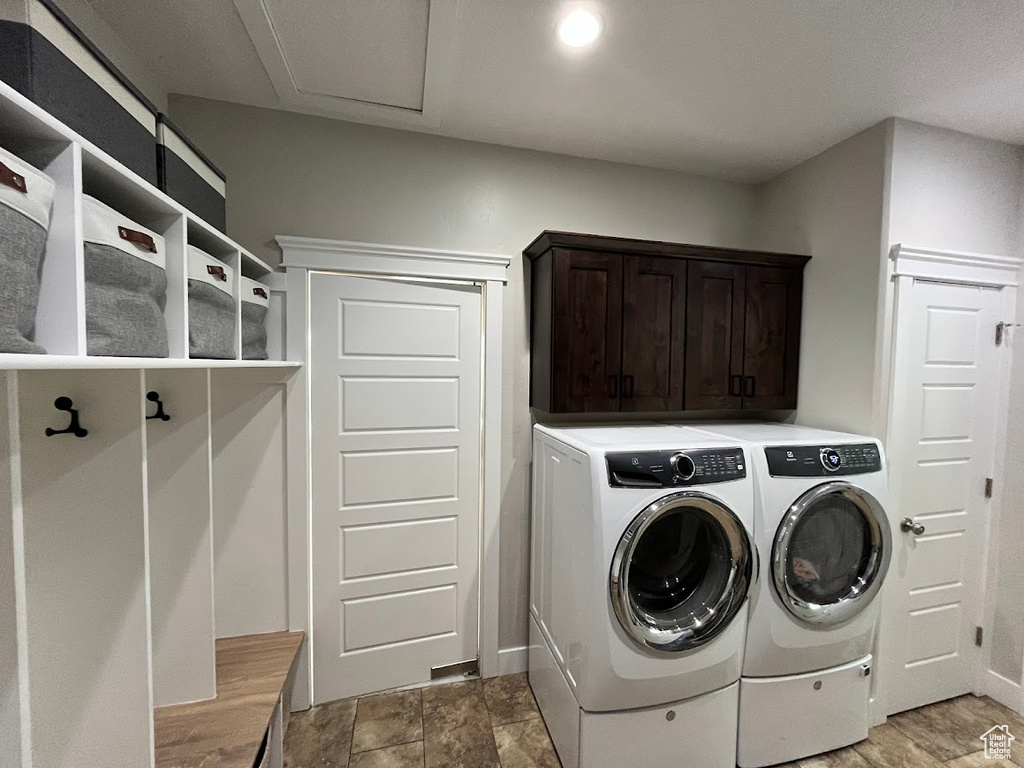 Washroom featuring washer and clothes dryer and cabinet space