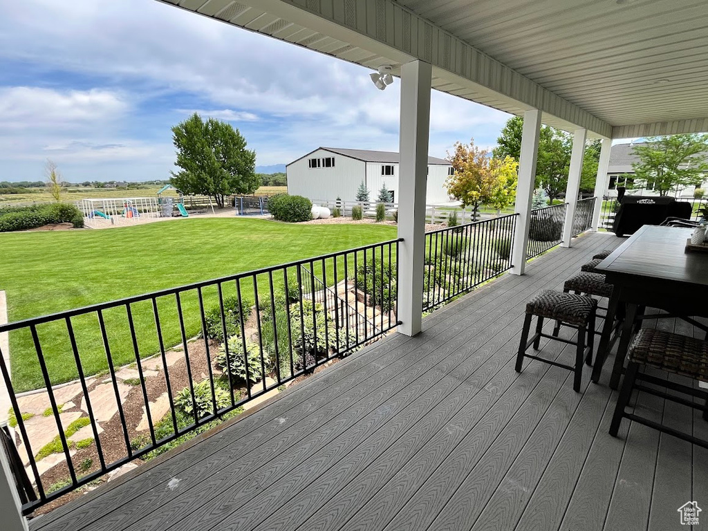 Wooden terrace with a playground and a lawn