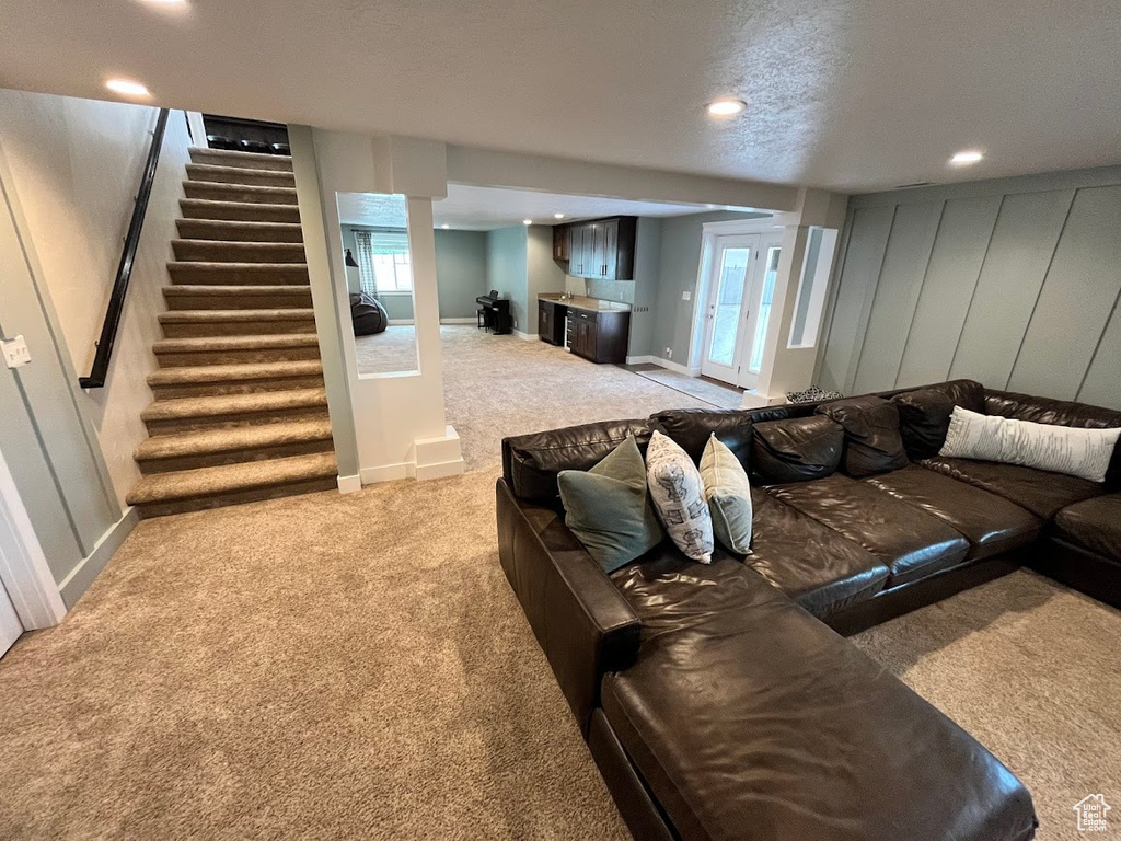 Carpeted living room featuring stairs, recessed lighting, and healthy amount of natural light