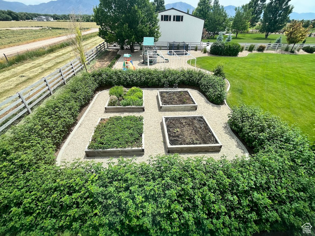 View of yard featuring a vegetable garden, a mountain view, and a view of countryside