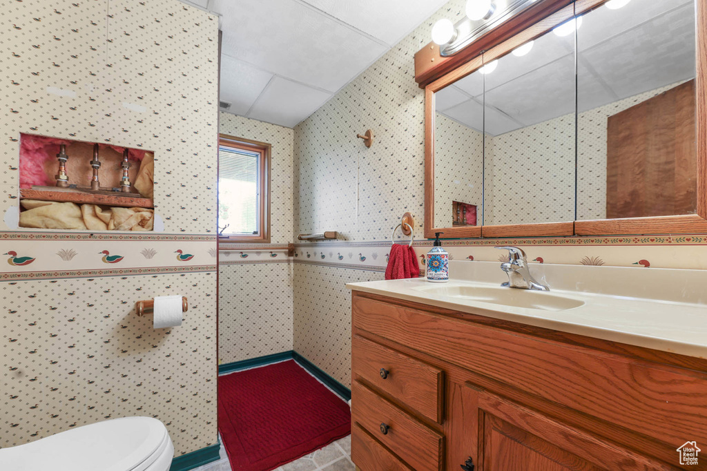 Bathroom with wallpapered walls and vanity