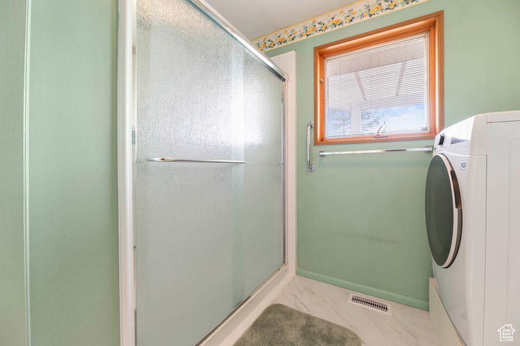 Washroom with washer / dryer and marble look tile flooring
