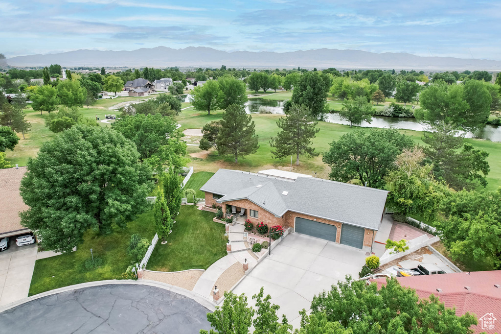 Aerial view of property and surrounding area featuring a water and mountain view and a golf club