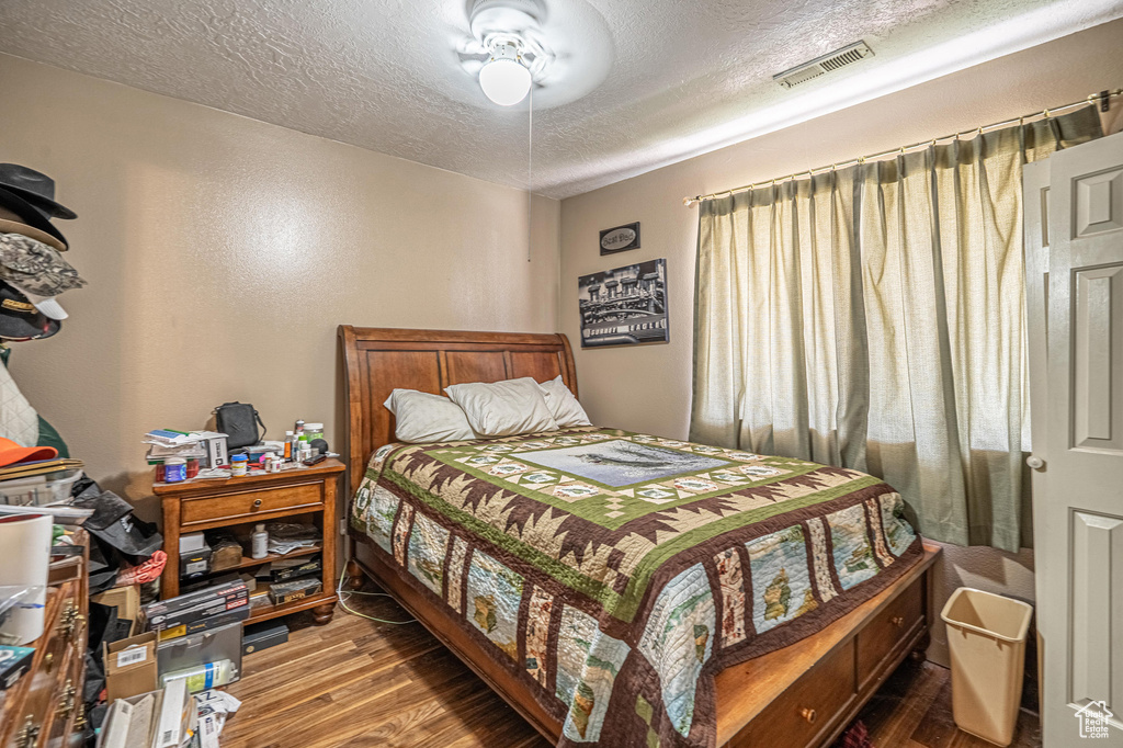 Bedroom featuring wood finished floors and a textured ceiling