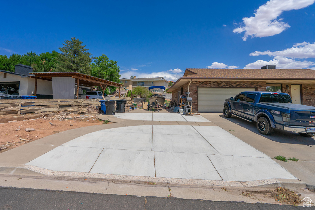 View of front of property with driveway, a garage, and brick siding