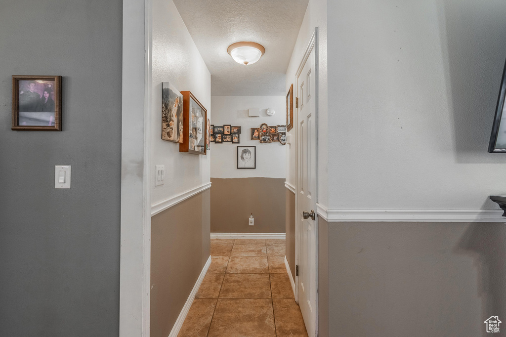 Corridor featuring tile patterned flooring and baseboards