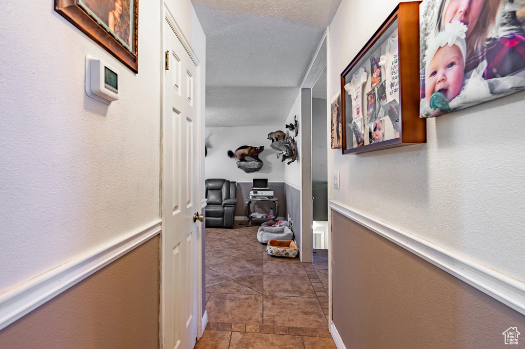 Hallway featuring a textured ceiling