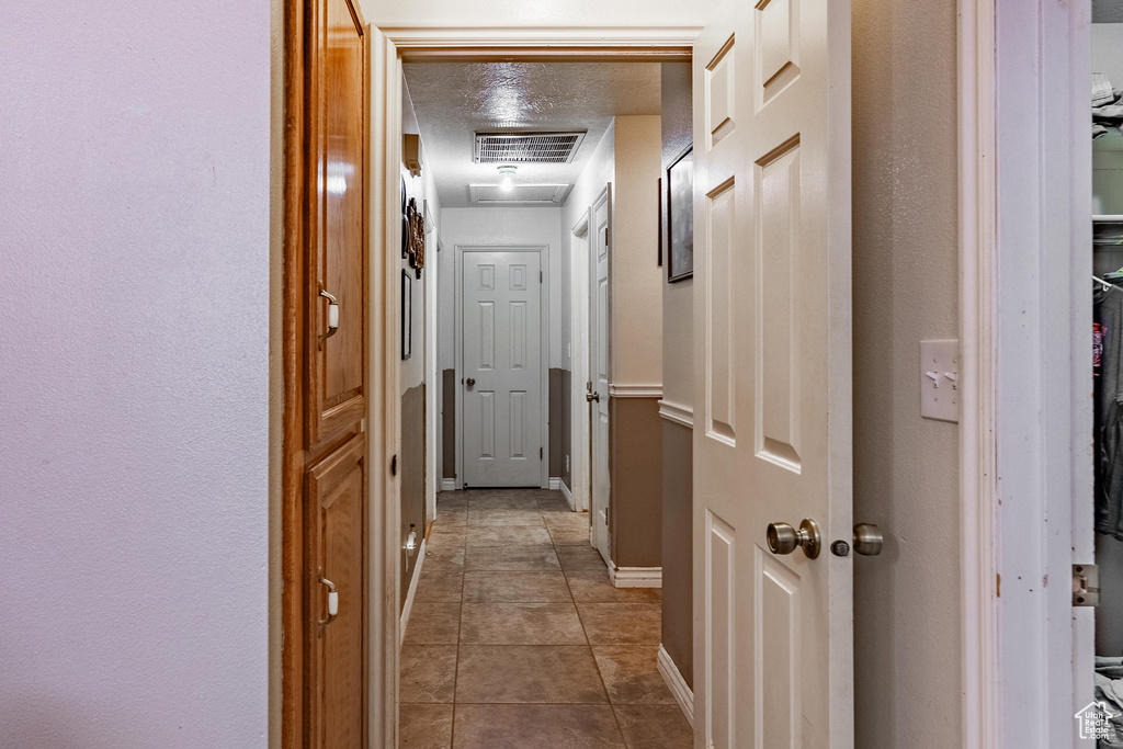 Corridor featuring baseboards and tile patterned floors
