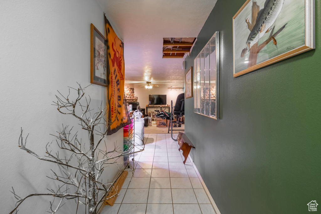 Hall featuring light tile patterned floors and baseboards