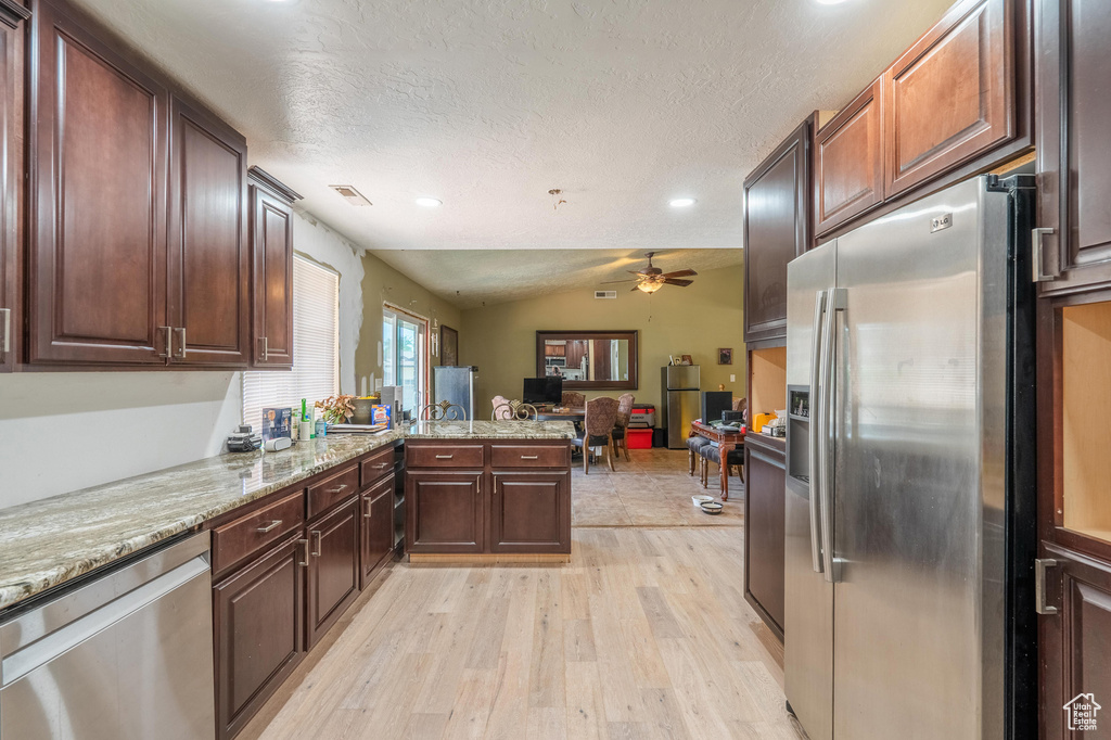 Kitchen featuring stainless steel appliances, a ceiling fan, light wood-type flooring, recessed lighting, and open floor plan