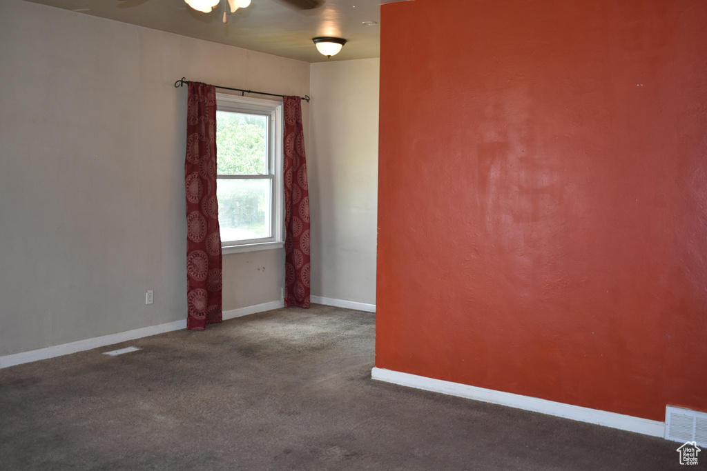 Unfurnished room with a ceiling fan and carpet