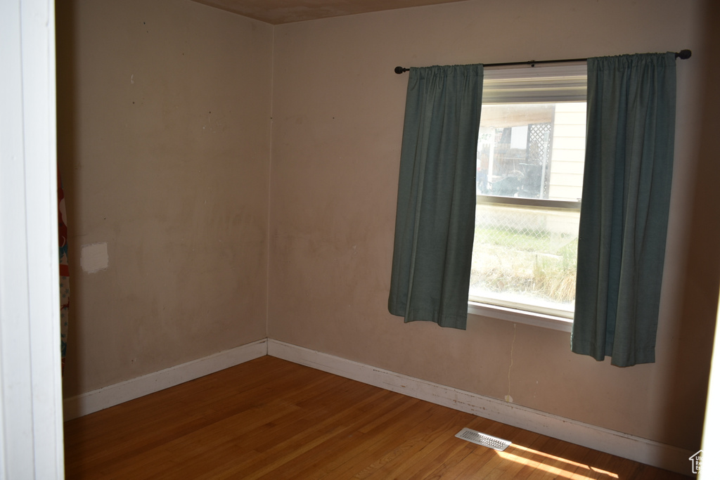 Spare room with wood finished floors and healthy amount of natural light