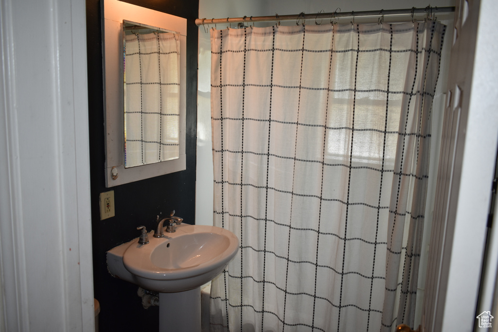 Full bath featuring a shower with shower curtain and a sink