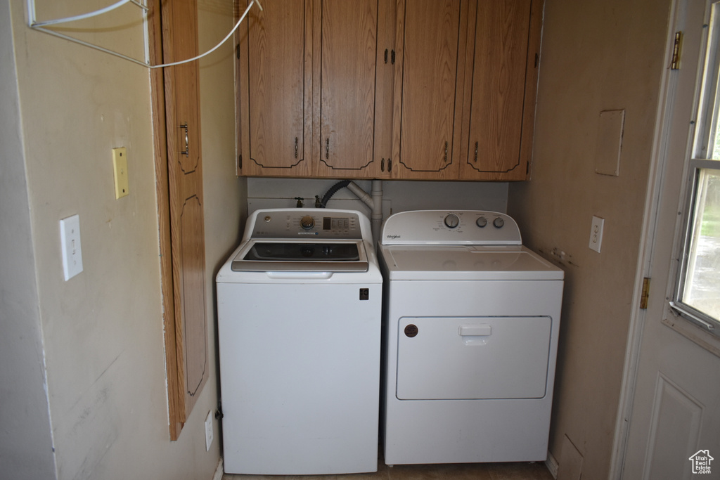Laundry room with washer and clothes dryer and cabinet space