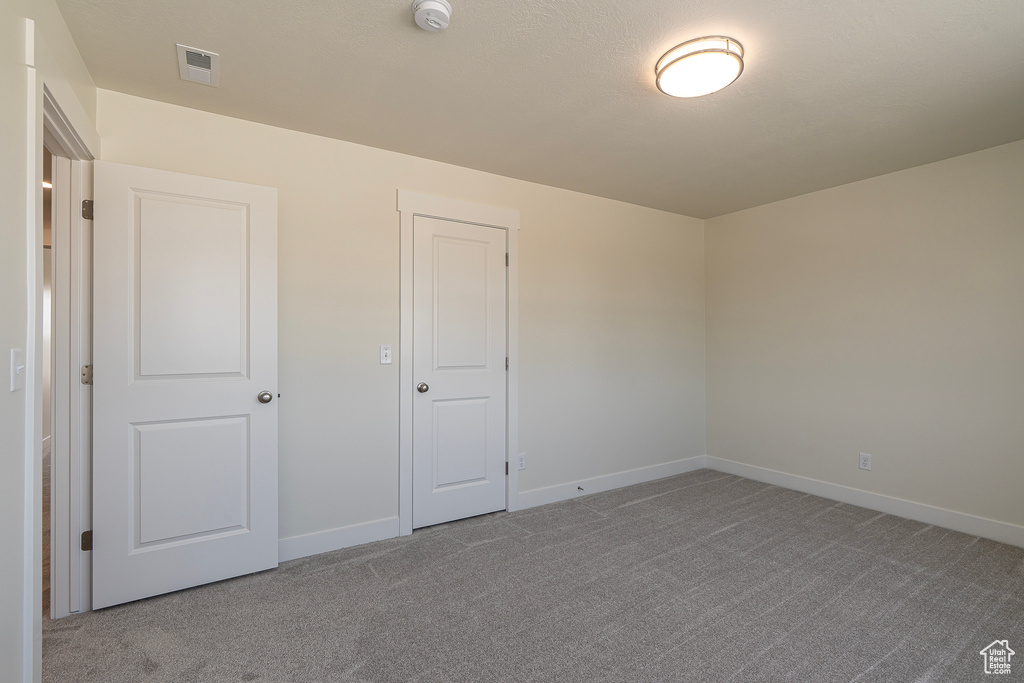 Unfurnished bedroom featuring carpet and baseboards