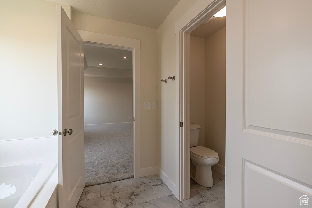 Bathroom with marble look tiles and recessed lighting