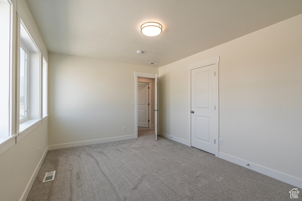 Unfurnished room with carpet and a smoke detector