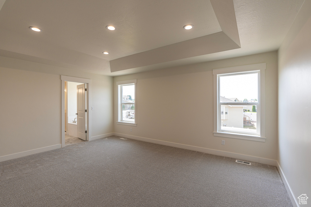 Empty room with light carpet and recessed lighting