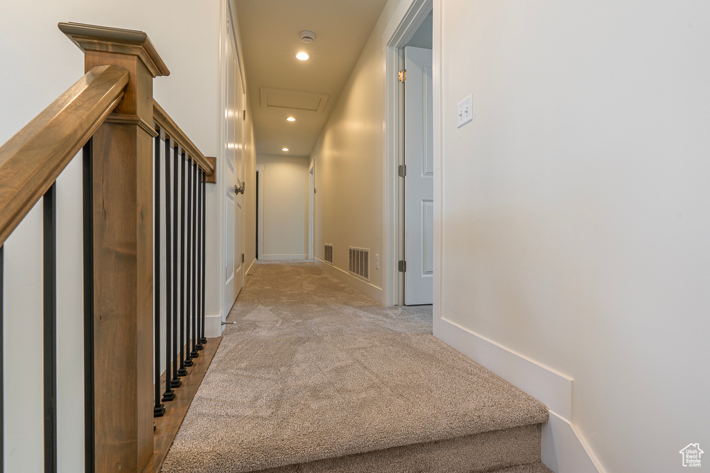 Corridor featuring light carpet, attic access, and recessed lighting