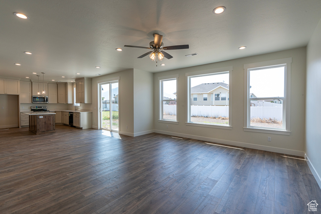 Unfurnished living room with dark wood-type flooring, recessed lighting, and a ceiling fan