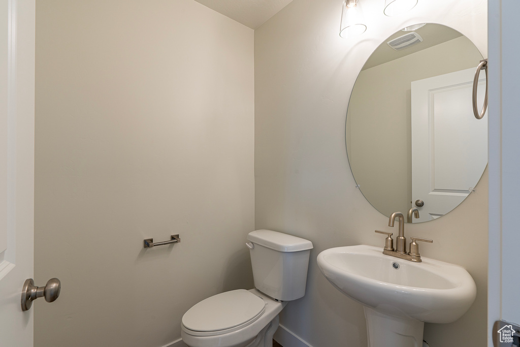 Half bathroom featuring toilet and baseboards