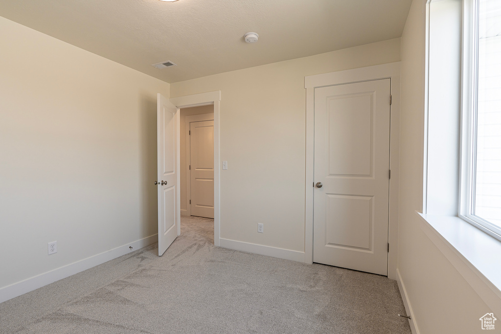 Unfurnished bedroom with carpet floors and baseboards