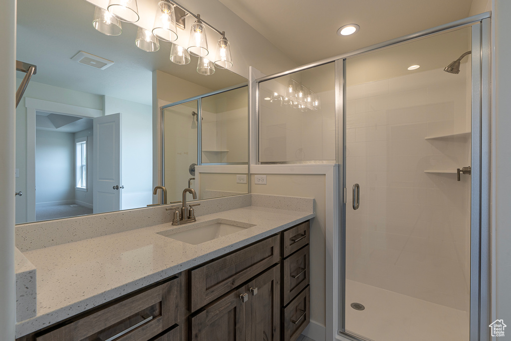 Bathroom with vanity, a shower stall, and recessed lighting