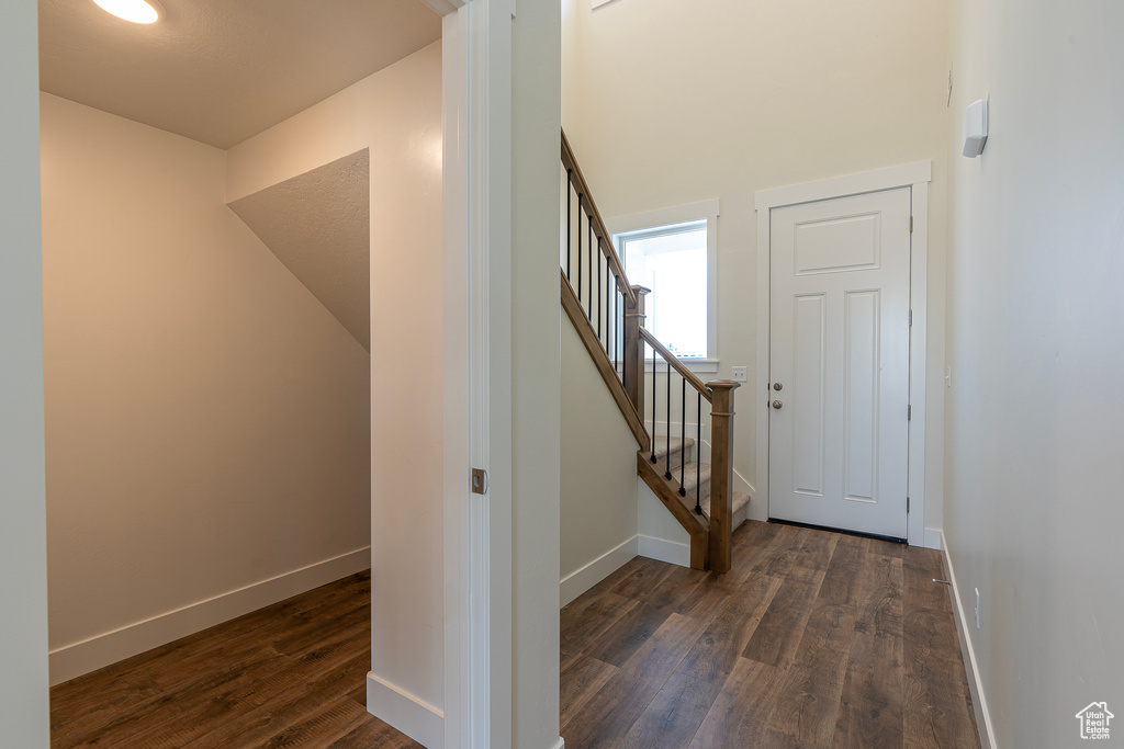 Staircase with wood finished floors and baseboards