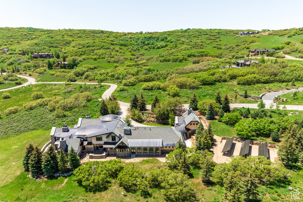 Aerial view of property and surrounding area with a heavily wooded area