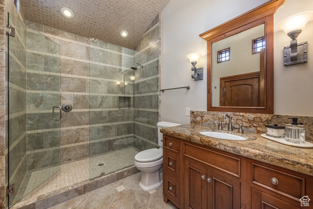Bathroom with vanity, a stall shower, vaulted ceiling, recessed lighting, and tile patterned flooring
