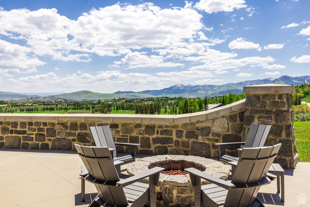 View of patio featuring an outdoor fire pit and a mountain view