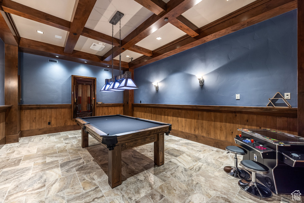 Rec room with stone finish floors, wainscoting, beamed ceiling, coffered ceiling, and wooden walls
